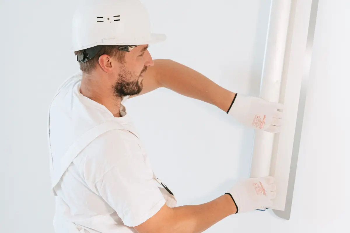 Drywall professional setting a metal corner bead against a finished wall