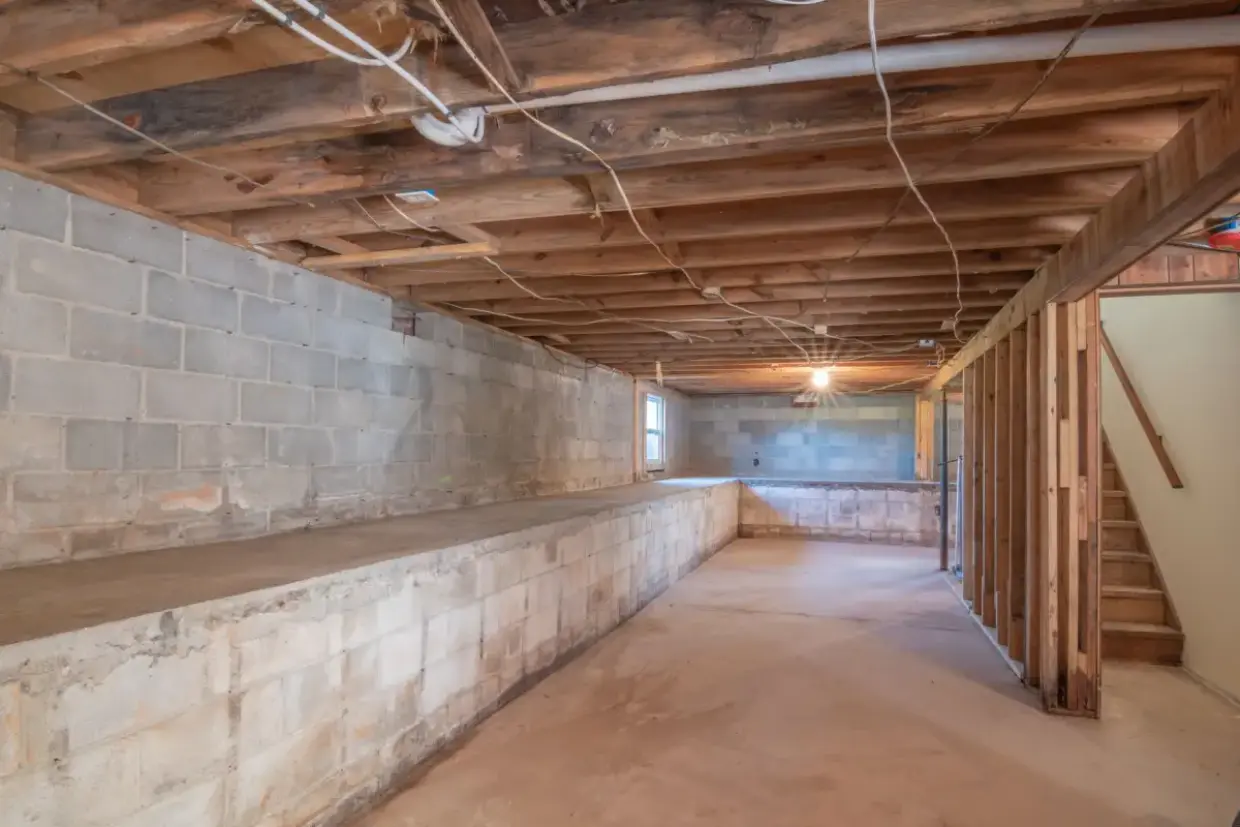 Below-grade block wall and joist bays before framing and board
