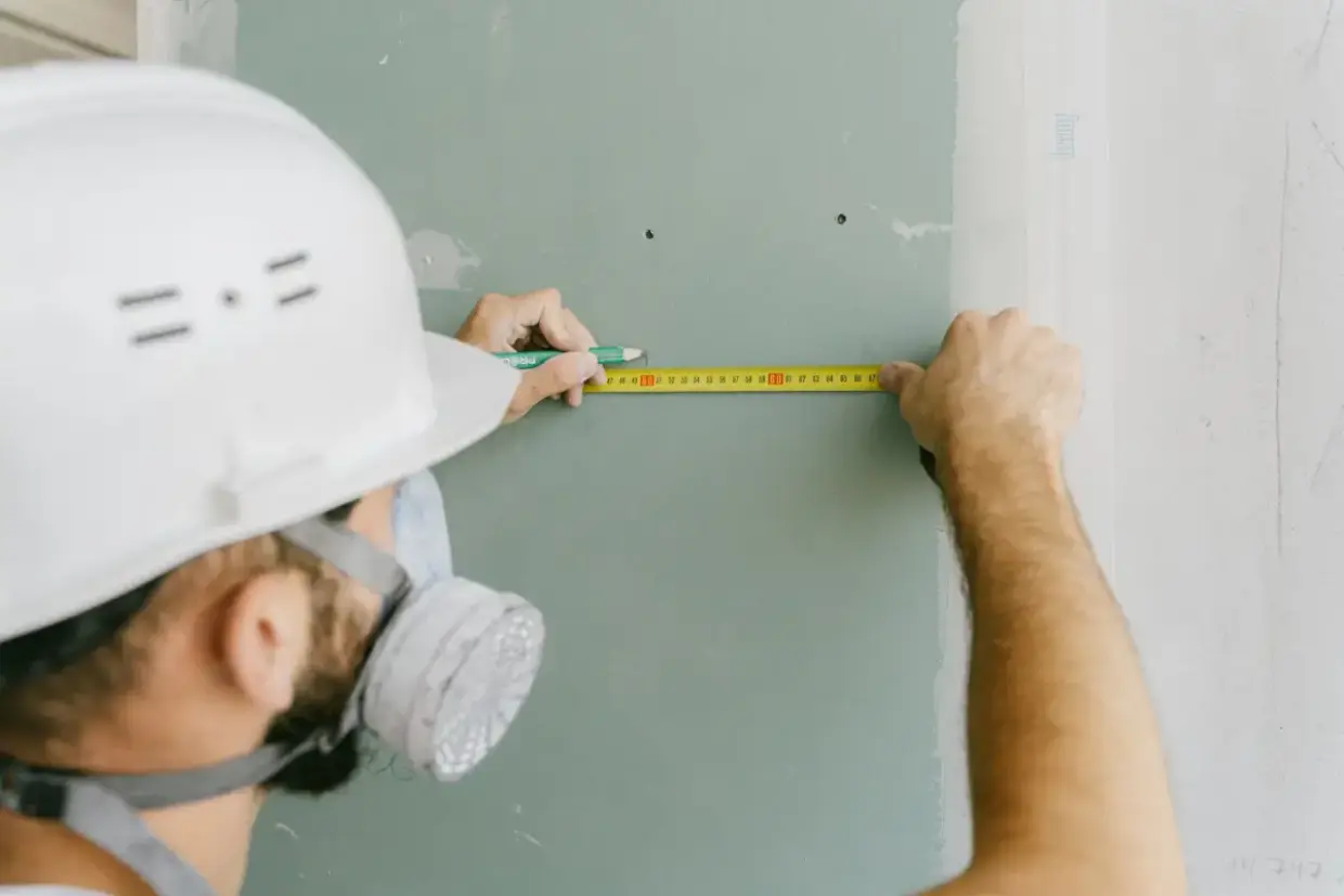 Ceiling drywall measured and marked before a repair section is cut