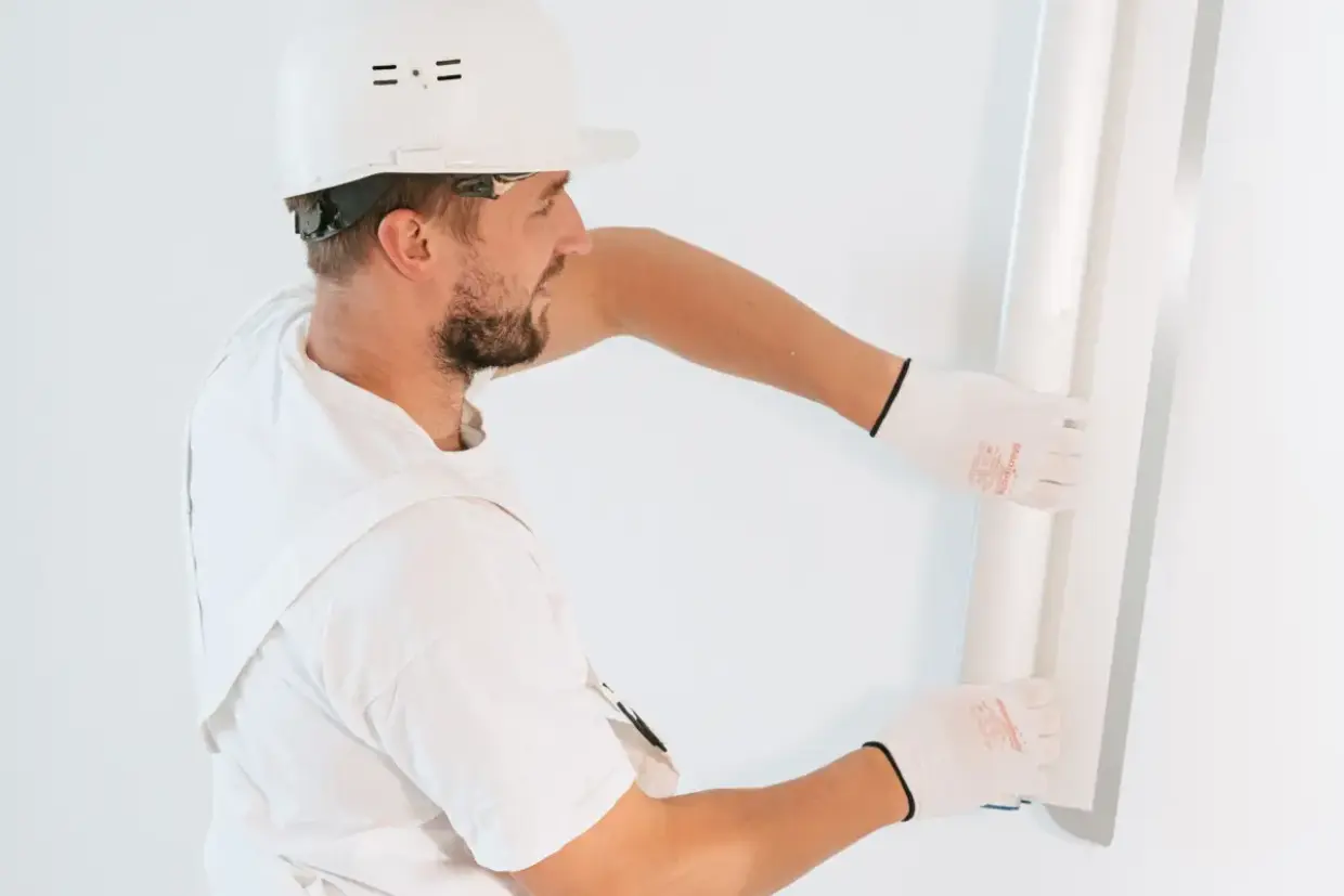 Drywall panel lifted into place against open framing during installation