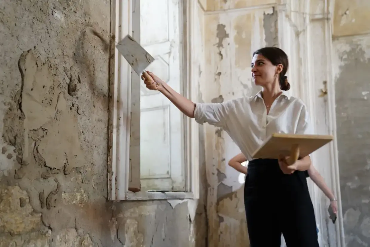 Plaster repair material worked into a damaged section of an older wall